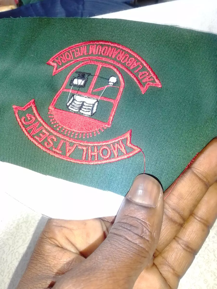 Embroidered school badge on green fabric